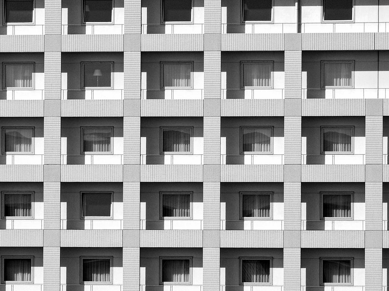 Modern building facade showcasing symmetrical architecture with repetitive window patterns in Japan.